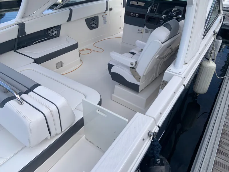 Slide: The Image of 2020 Chaparral 280 OSX boat interior with white seating and modern dashboard. - 17