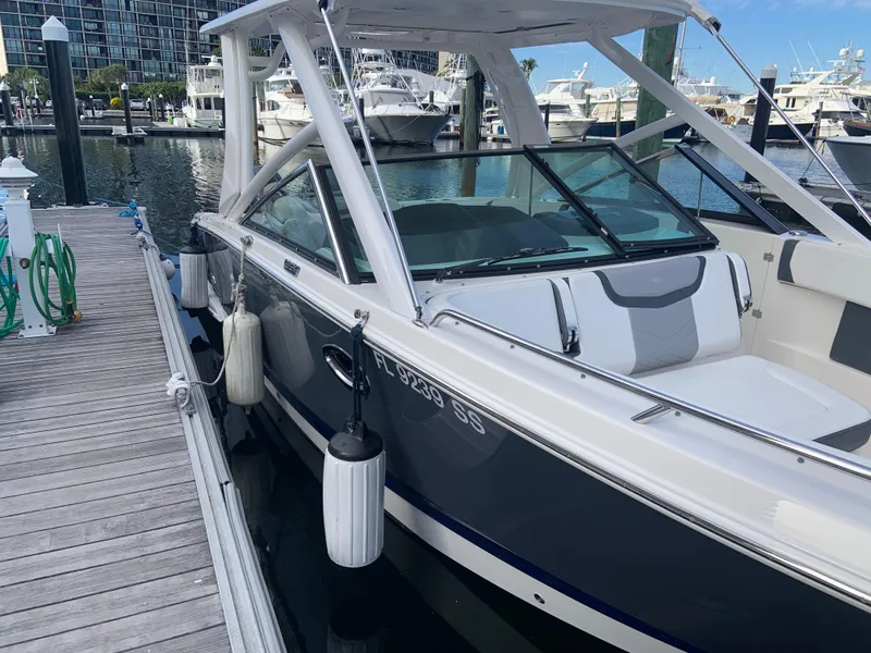 Slide: The Image of 2020 Chaparral 280 OSX docked at a marina with other boats in the background. - 5