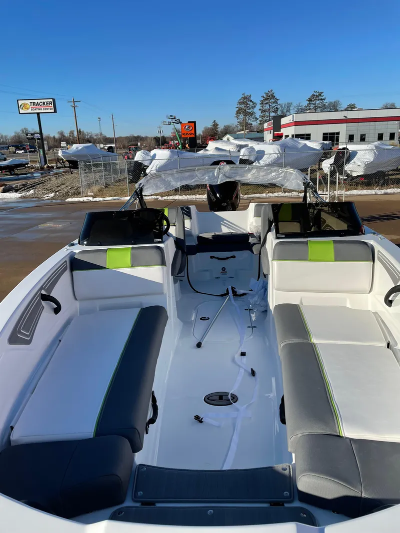 Slide: The Image of 2024 Tahoe T21 boat interior with gray and green seating, parked outdoors. - 3