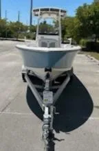 Slide: The Image of 2024 Mako 214 CC boat on a trailer in a parking lot. - 2