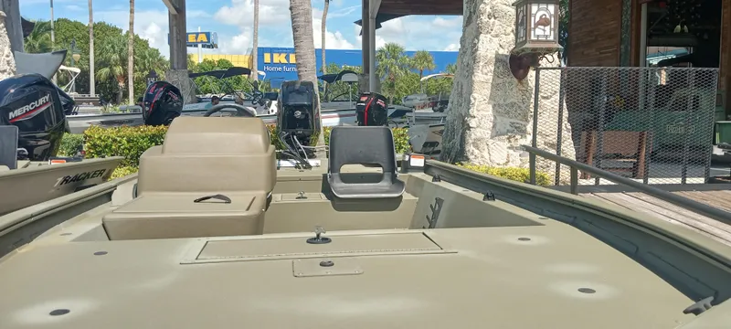 Slide: The Image of 2024 Tracker Grizzly 1754 SC boat displayed outdoors with motor engines in the background. - 2