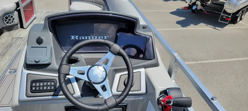 Slide: The Image of 2024 Ranger Reata 243C boat dashboard with steering wheel and control panel. - 4