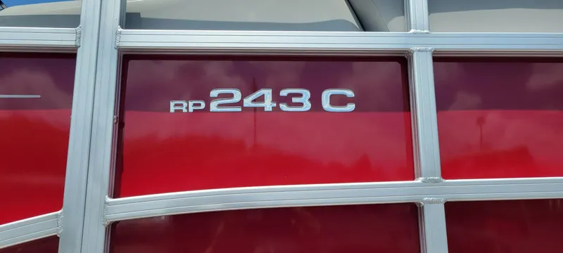 Slide: The Image of 2024 Ranger Reata 243C boat, red exterior with silver trim and model badge. - 6