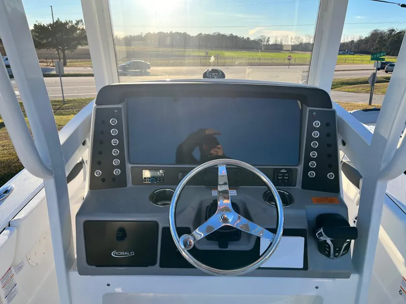 Slide: The Image of 2024 Robalo 246 Cayman boat dashboard with steering wheel and control panel. - 10