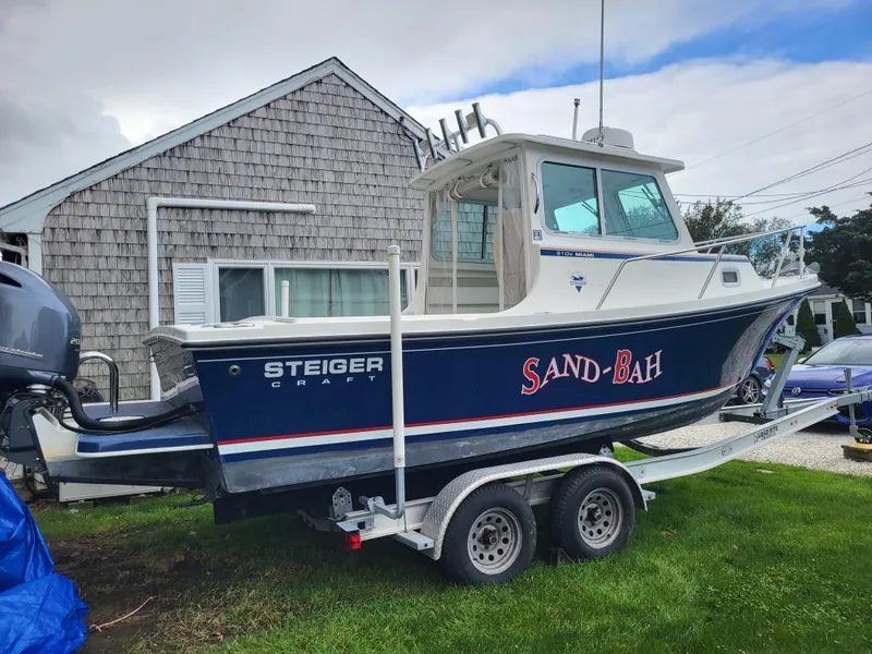 Slide: The Image of 2018 Steiger Craft 21 DV MIAMI boat on trailer, named Sand-Bah, parked beside a house. - 8