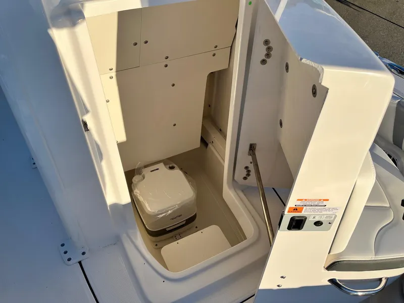 Slide: The Image of 2024 Robalo 246 Cayman boat interior with a compact toilet. - 15