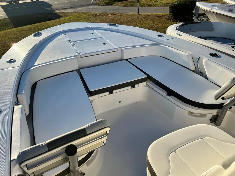 Slide: The Image of 2024 Robalo 246 Cayman boat interior with cushioned seating and storage compartments. - 17