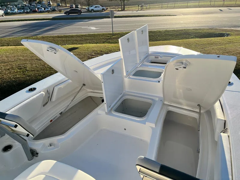 Slide: The Image of 2024 Robalo 246 Cayman boat with open storage compartments and seating. - 18
