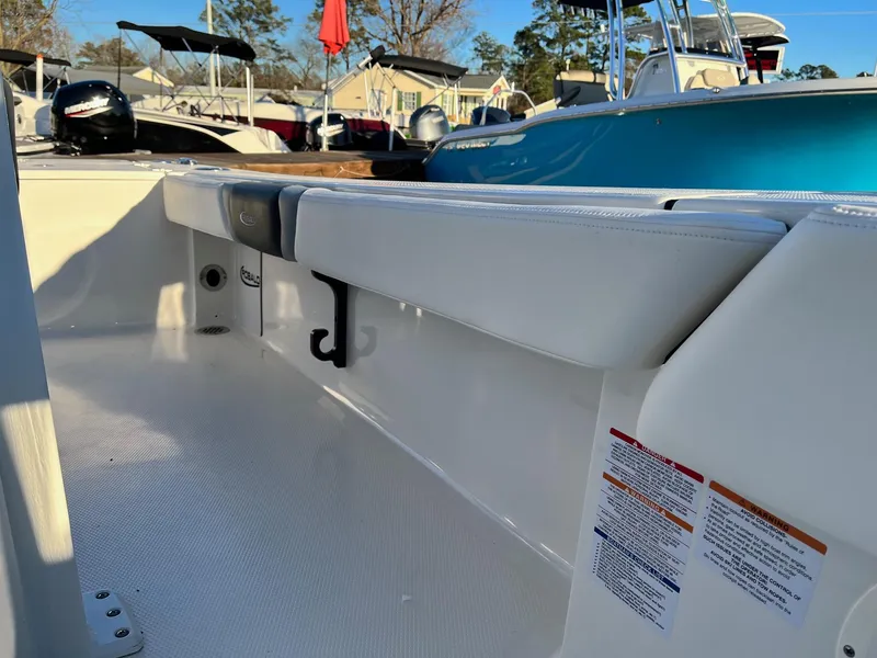 Slide: The Image of 2024 Robalo 246 Cayman boat interior with white seating and storage compartments. - 14