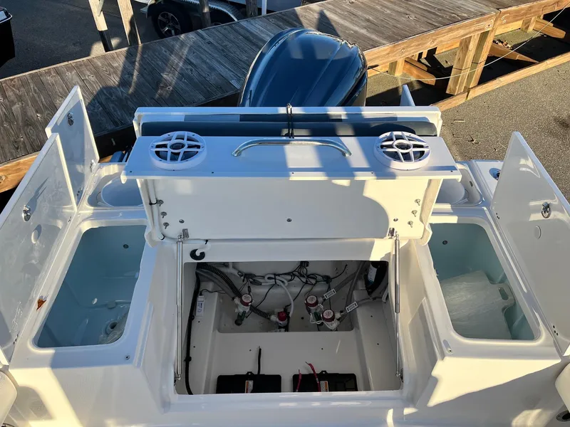 Slide: The Image of 2024 Robalo 246 Cayman boat with open storage compartments and engine bay. - 7