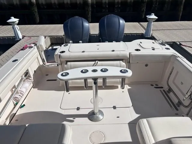Slide: The Image of 2019 Grady-White Freedom 325 boat interior with dual outboard motors and fishing rod holders. - 13