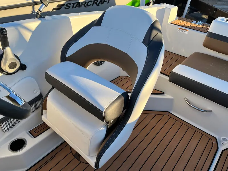 Slide: The Image of 2024 Starcraft SVX 191 boat interior with captain's chair and teak flooring. - 8