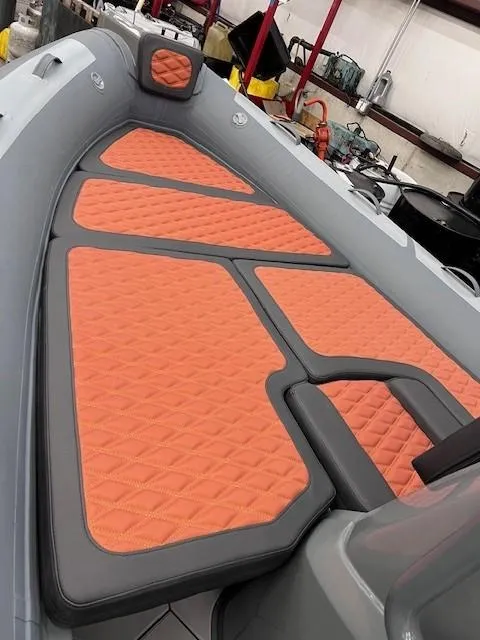 Slide: The Image of 2024 Highfield Sport 660 boat with orange and gray cushioned seating. - 11