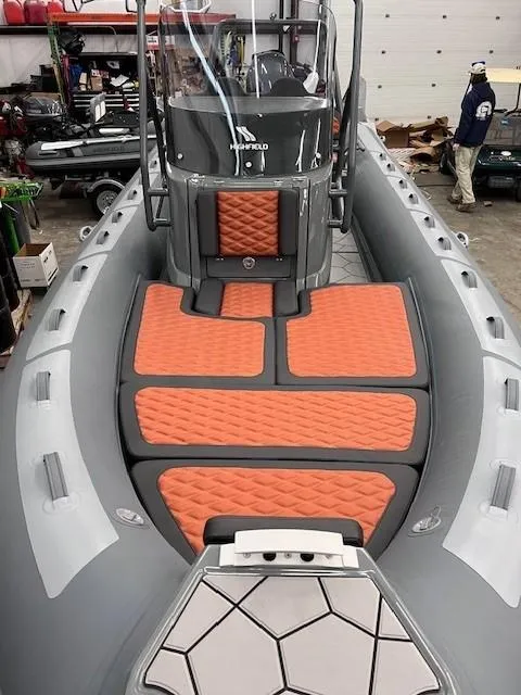 Slide: The Image of 2024 Highfield Sport 660 boat with orange and gray interior in a workshop. - 15