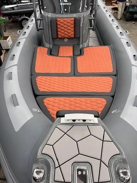 Slide: The Image of 2024 Highfield Sport 660 boat with orange cushioned seating and grey deck. - 4