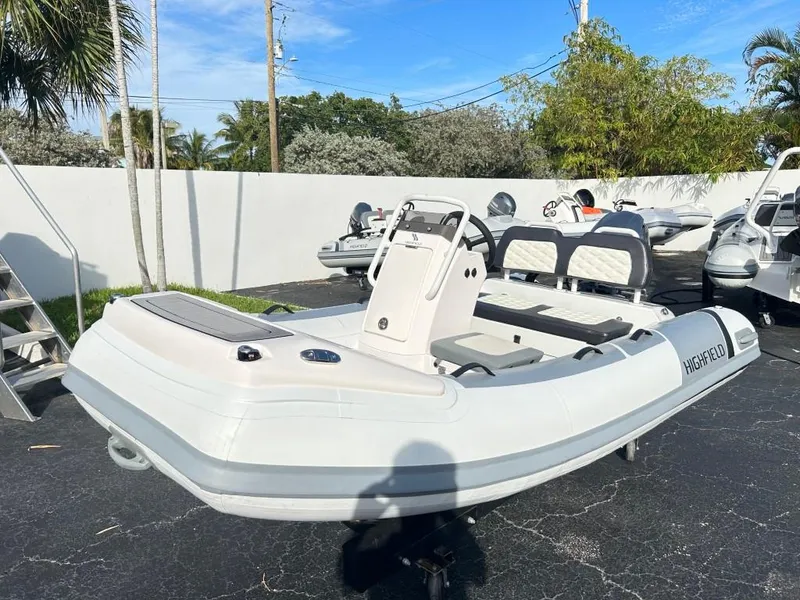 Slide: The Image of 2023 Highfield Sport 330 inflatable boat on display in a sunny outdoor showroom. - 2