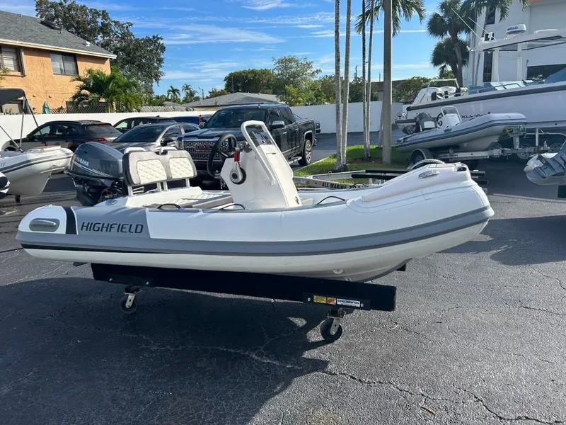 Slide: The Image of 2023 Highfield Sport 330 inflatable boat on a trailer in a parking lot. - 5