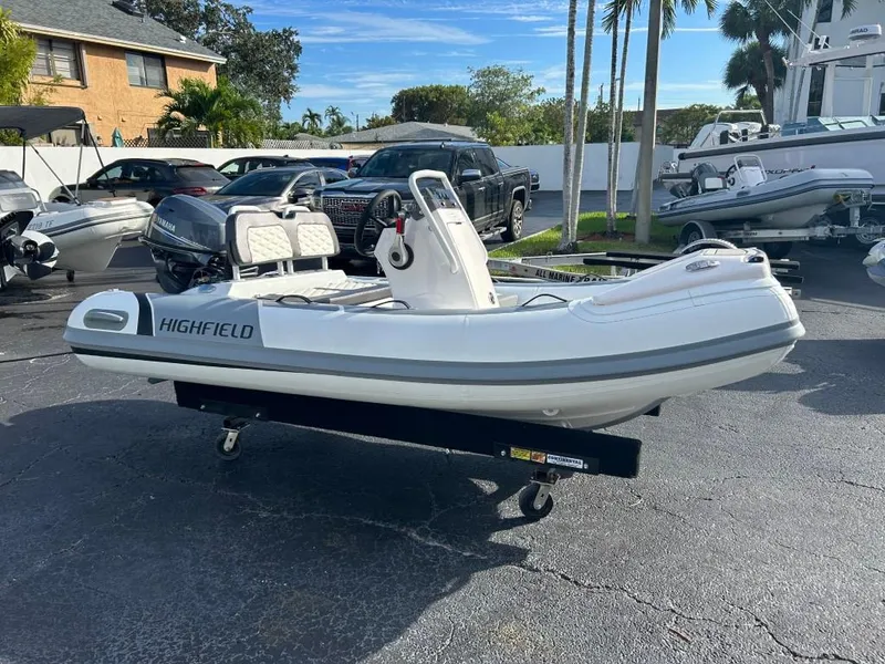 Slide: The Image of 2023 Highfield Sport 330 inflatable boat on a trailer in a parking lot. - 7