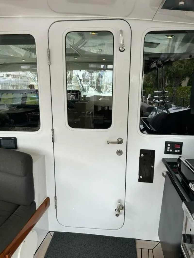 Slide: The Image of Interior view of 1983 Palmer Johnson 110 Cruising Sloop with white door and seating area. - 25