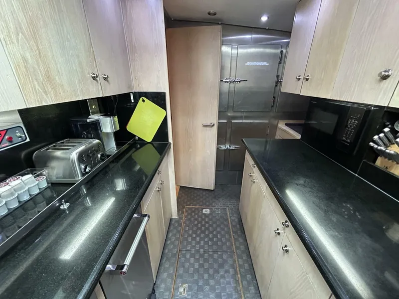 Slide: The Image of 1983 Palmer Johnson 110 Cruising Sloop kitchen with black countertops and modern appliances. - 49