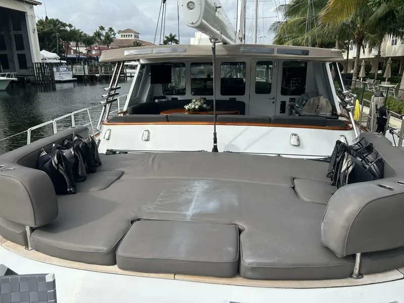 Slide: The Image of Palmer Johnson 110 Cruising Sloop 1983, spacious deck with cushioned seating, docked at marina. - 8