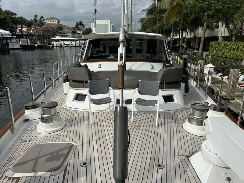 Slide: The Image of Palmer Johnson 110 Cruising Sloop 1983 docked, showcasing spacious deck and seating area. - 9