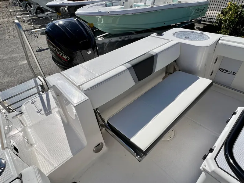 Slide: The Image of 2024 Robalo R230 boat interior with fold-down seating and outboard motor. - 12