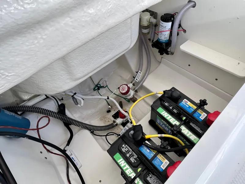 Slide: The Image of 2024 Robalo R230 boat battery compartment with wiring and components. - 14