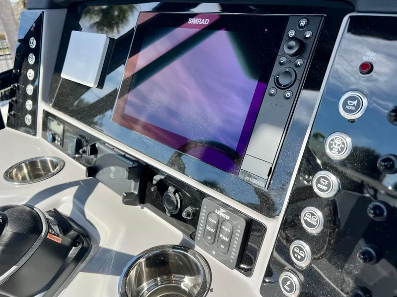 Slide: The Image of 2024 Robalo R230 boat dashboard with Simrad display and control buttons. - 19