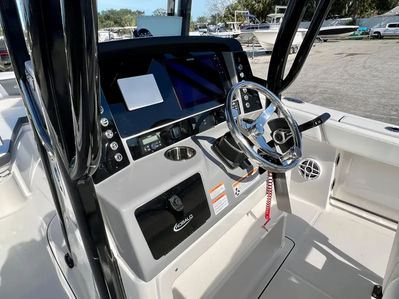 Slide: The Image of 2024 Robalo R230 boat dashboard with steering wheel and control panel. - 22
