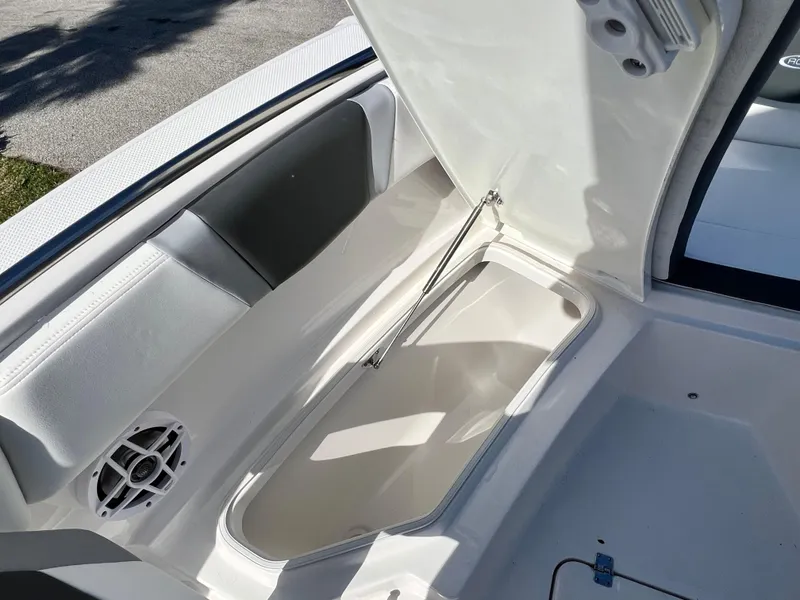 Slide: The Image of 2024 Robalo R230 boat storage compartment with open lid and speaker. - 25