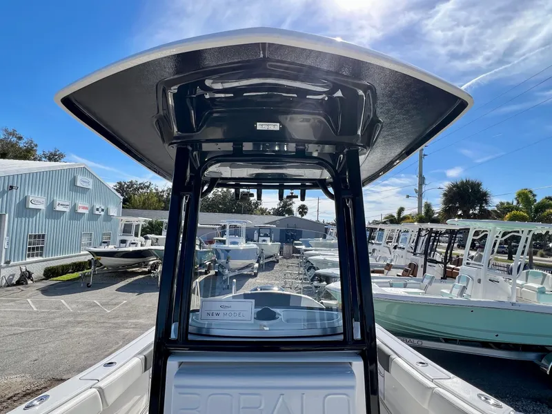 Slide: The Image of 2024 Robalo R230 boat at dealership, showcasing T-top and console. - 29