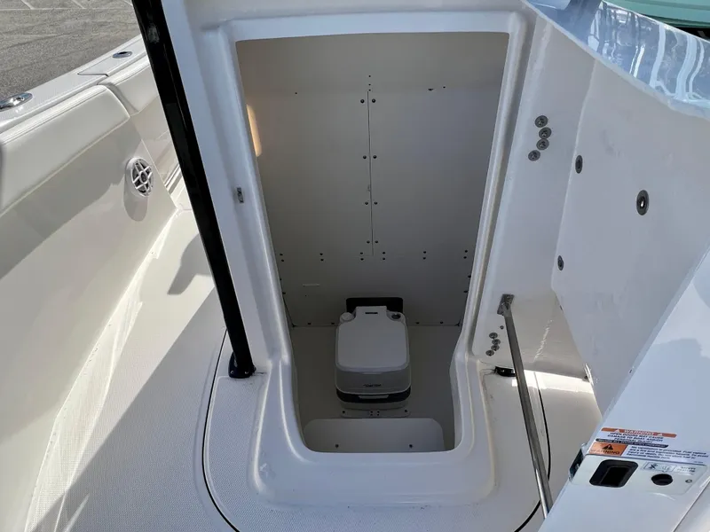 Slide: The Image of 2024 Robalo R230 boat interior with a compact marine toilet. - 30