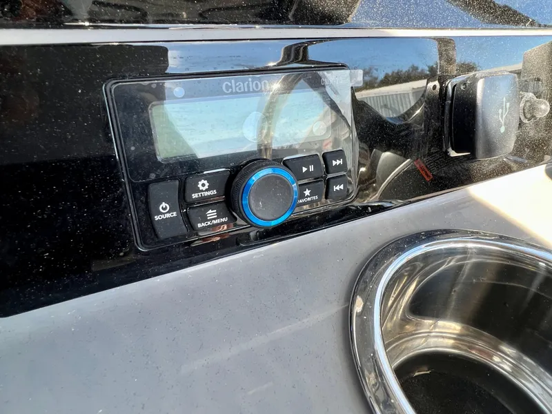 Slide: The Image of 2024 Robalo R230 boat dashboard with Clarion audio system and USB port. - 32