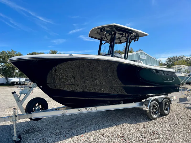 Slide: The Image of 2024 Robalo R230 boat on trailer under clear blue sky. - 5