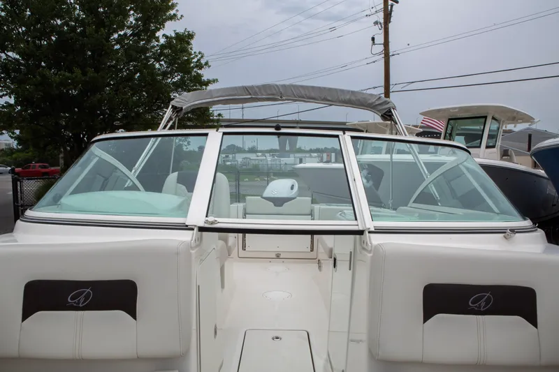 Slide: The Image of 2024 Sailfish 226 DC boat with open cockpit and windshield, docked outdoors. - 12