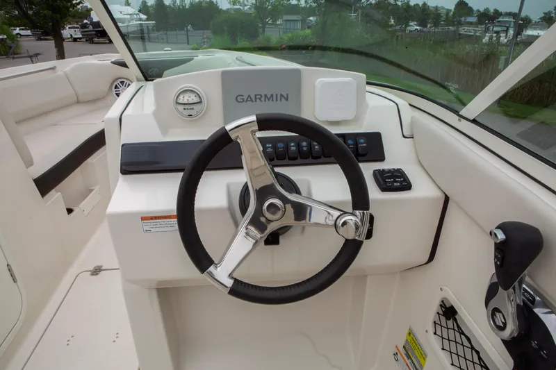 Slide: The Image of 2024 Sailfish 226 DC boat dashboard with Garmin navigation system and steering wheel. - 19