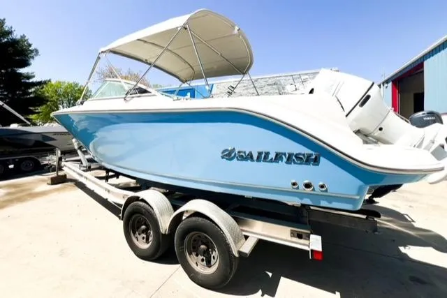 Slide: The Image of 2024 Sailfish 226 DC boat on a trailer in a marina. - 2