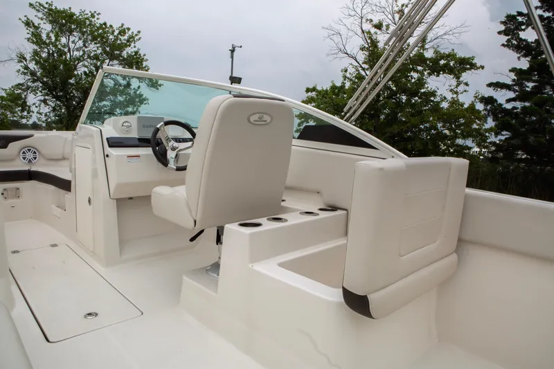 Slide: The Image of 2024 Sailfish 226 DC boat interior with white seating and steering wheel. - 26
