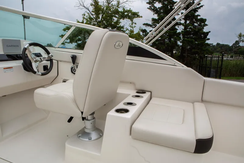 Slide: The Image of 2024 Sailfish 226 DC boat interior with steering wheel and seating area. - 27