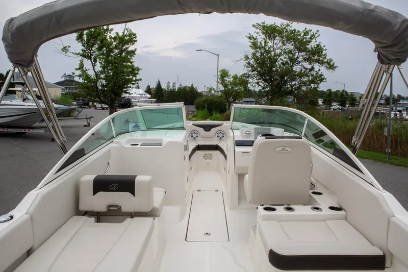 Slide: The Image of 2024 Sailfish 226 DC boat interior with seating and dashboard, docked outdoors. - 29