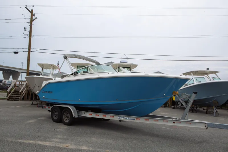 Slide: The Image of 2024 Sailfish 226 DC boat on trailer, blue hull, parked outdoors. - 32