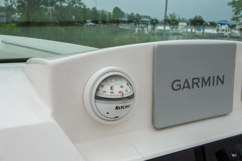 Slide: The Image of Compass and Garmin device on 2024 Sailfish 226 DC boat dashboard. - 5