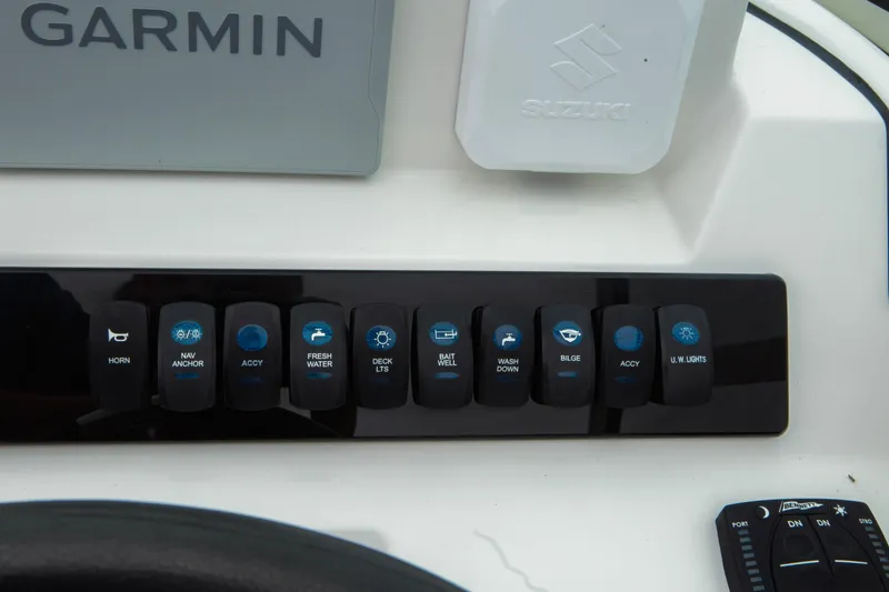 Slide: The Image of Control panel of 2024 Sailfish 226 DC boat with various switches and Garmin device. - 7