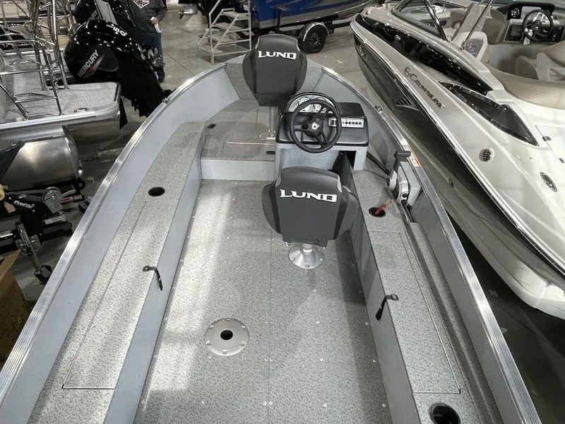 Slide: The Image of 2024 Lund Fury 1600 SS fishing boat interior with steering console and seating. - 11