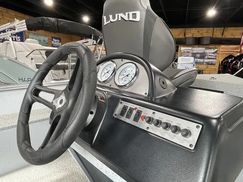 Slide: The Image of 2024 Lund Fury 1600 SS boat dashboard with steering wheel and control panel. - 8