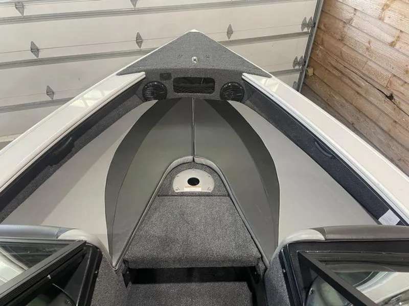 Slide: The Image of 2024 Lund Crossover XS 1875 boat interior, front view in a garage. - 12