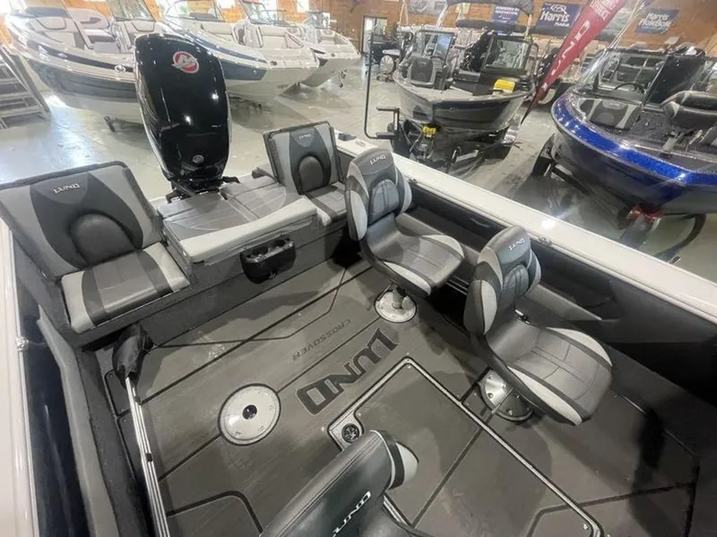 Slide: The Image of 2024 Lund Crossover XS 1875 boat interior with seating and motor in showroom. - 9