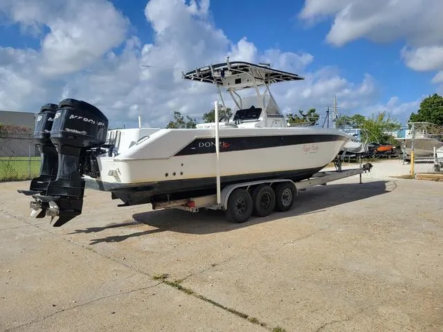 Slide: The Image of 1998 Donzi 35 ZF boat on trailer with twin outboard engines, parked outdoors. - 4