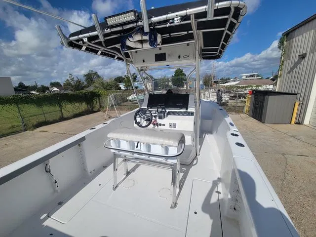 Slide: The Image of 1998 Donzi 35 ZF boat with open deck, steering console, and T-top in a sunny outdoor setting. - 8